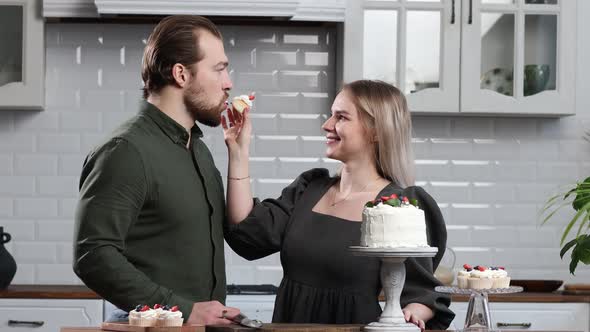 Pastry Chef Confectioner Young Caucasian Woman with Husband Boyfriend Man Try Taste of Cake on
