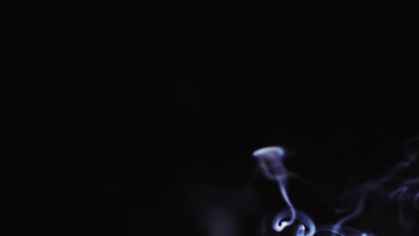 Realistic cloud smoke with a streamlined pattern. Abstract blue smoke on dark background in slow mot alt