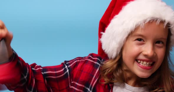 Portrait of Christmas little Girl in Santa Hat with bell, smiling child alt