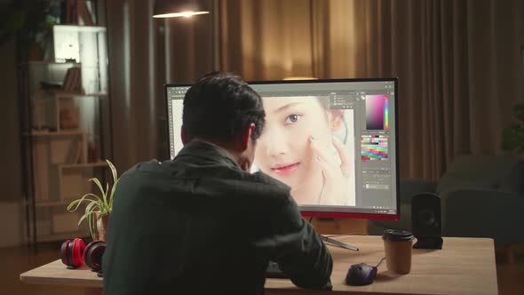 Tired Asian Male Digital Editor Works In Photo Editing Software On His Personal Computer alt