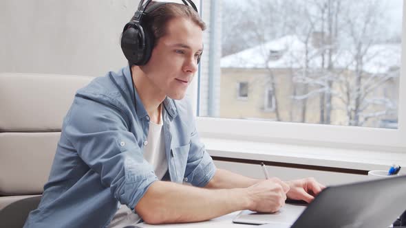 Workplace of freelance worker at home office. Young man works using computer. alt