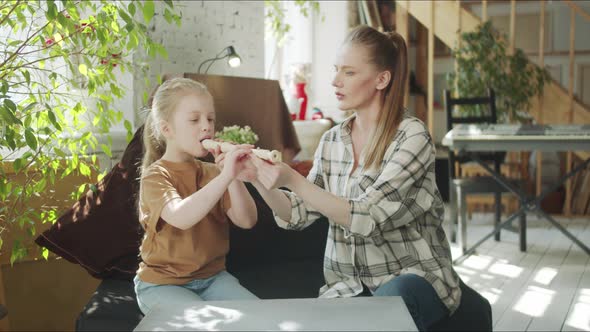 A Woman Tells Her Daughter How to Use a Flute and Shows Her Device alt