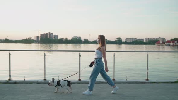 Woman Wearing White Face Mask Walking with Dog. alt