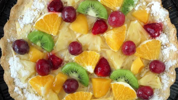 Top View of Cake with Fresh Fruit and Berries with Cream Rotates on Tray