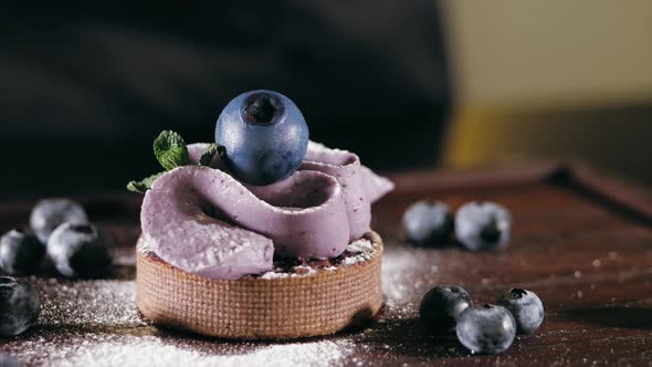 Pastry Chef Is Puts a Berry on Top of Cake and Adds Decoration Element Closeup