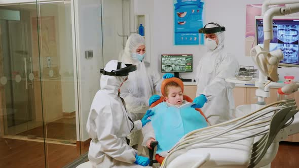 Dentist Doctor in Coverall Finishing Dental Treatment of Child in Stomatological Clinic alt