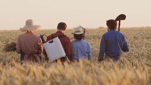 Team of Gardeners Walking in Wheat Filed alt