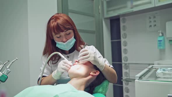 Dental clinic. Reception, examination of the patient. Teeth care. Dentist curing a girl patient alt
