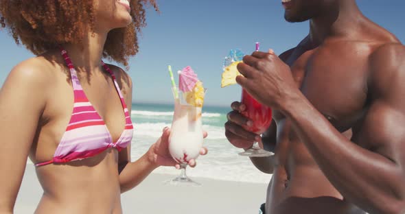 African american couple drinking cocktail seaside alt