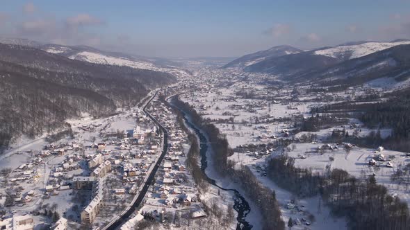 Scenic Landscape of Small Town Among Forest and Mountain Valleys in Winter Carpathians Aerial Drone