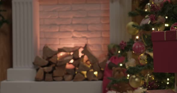 Red Colored Christmas Gift Lying Under the Tree is Taken By Child Wearing Yellow alt