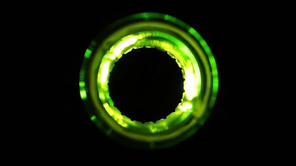 A green beer bottle shimmering on black background