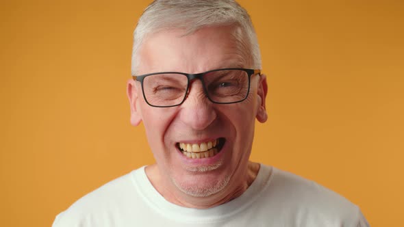 Mature Elderly Man Screaming Loud Against Yellow Background