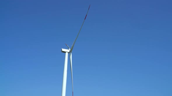 Wind turbine generating electricity on blue sky, sustainable development, renewable energy alt