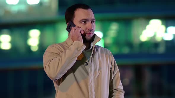 Businessman Making a Call By Cellphone Outdoors in the Evening. alt