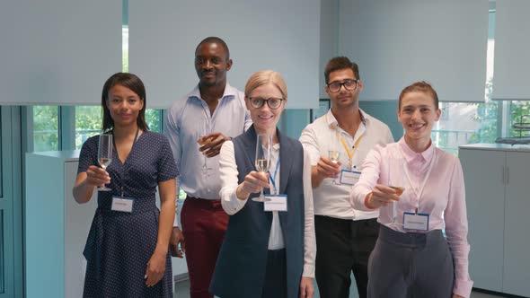 Mature Businesswoman with Employees Raise Champagne Glasses Smiling at Camera alt