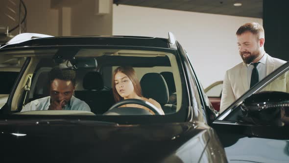 Positive Couple Sitting Inside Luxury Black Car and Talking with Competent alt