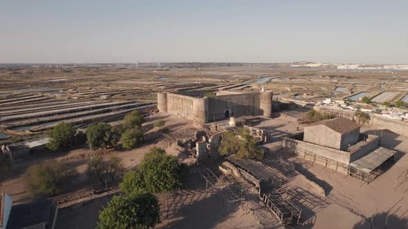 Low level drone flying through Castelo de Castro Marim Castle reveals the salt flats in parish town. alt