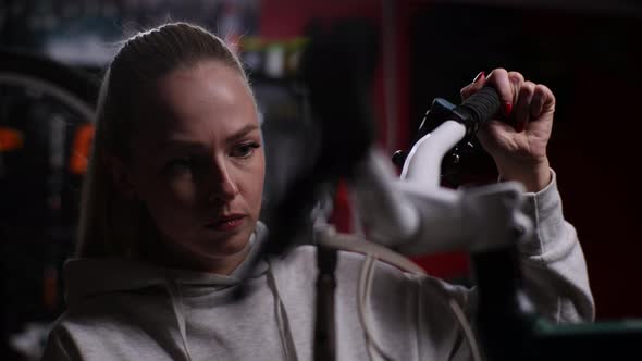 Closeup of Female Bike Repairman Checking and Fixing Bicycle Handlebar with Special Tools Working in alt
