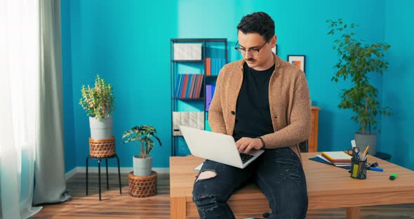 Comfortably Elegantly Dressed Man Working in Office Sits at Desk with Laptop on Lap Ambitious alt