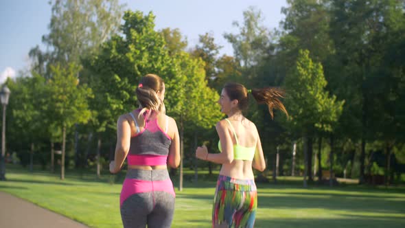 Beautiful Female Runners Jogging in Summer Park alt