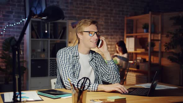 Slow Motion of Male Office Worker Chatting on Mobile Phone Indoors Smiling alt