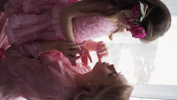 Backstage the Photographer with Beautiful Family Mother and Daughter in Pink Dress Near Large Window alt