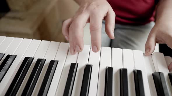 Close up of woman's hand playing on the electric piano. Female synthesizer player. alt