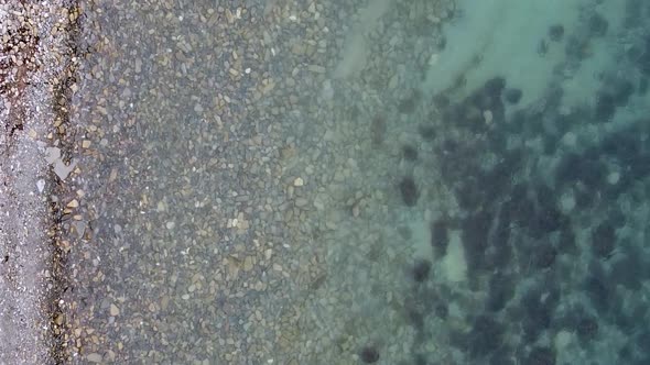 Vertical orientation video: Layered rocky bottom of sedimentary rocks underwater