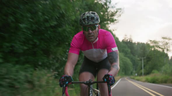 Tracking shot of a male cyclist on country road.  Fully released for commercial use.