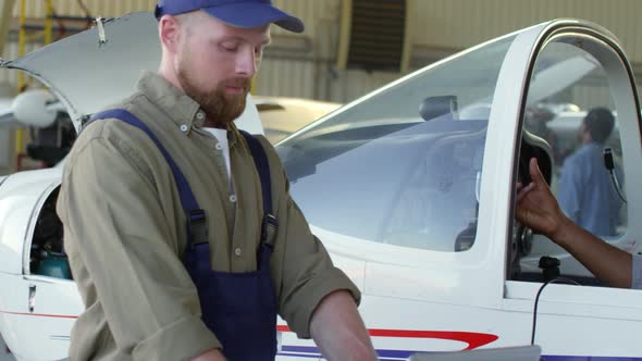 Male Pilot Talking to Aircraft Mechanic alt