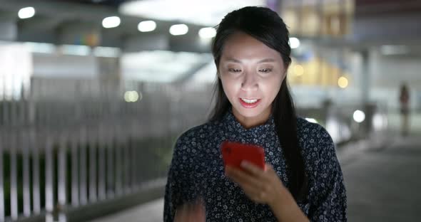 Woman use of cellphone online in city at night alt