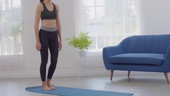 Athletic Healthy Asian young woman in sportswear workout legs excercise at home alt