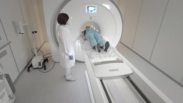 Doctor Makes an MRI Scan for a Patient in a Clinic alt