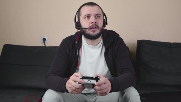 Serious Gamer with Headset and Joystick Participates in Online Gaming Tournament