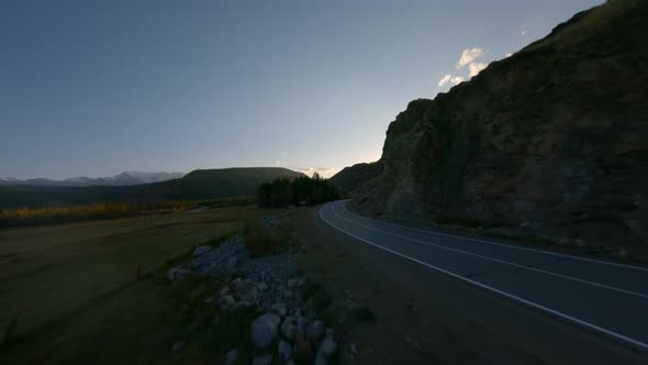 Aerial View Flying Over Empty Road Highway Near Natural Mountain at Sunset alt