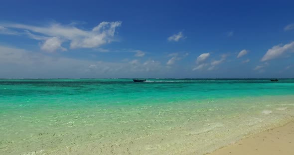 Natural aerial clean view of a sandy white paradise beach and blue ocean background in vibrant 4K alt
