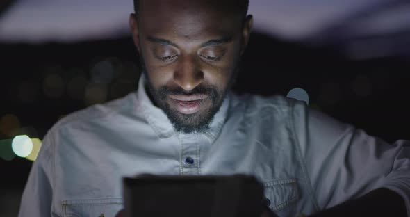Afro American Man Using Smartphone in Night City Lights Backgorund alt