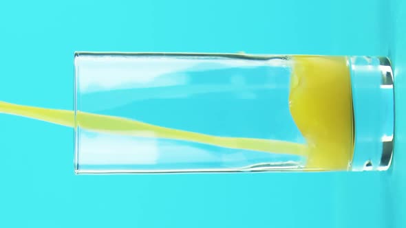 Vertical Video Closeup Shot of Fruit Orange Multifruit Juice Cold Beverage Drink Pooring Into Glass