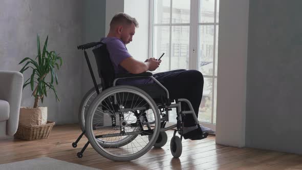 Man using cell phone on wheelchair alt