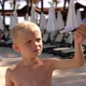 Closeup of a Little Boy Playing with a Toy Airplane Near the Pool in the Hotel - VideoHive Item for Sale