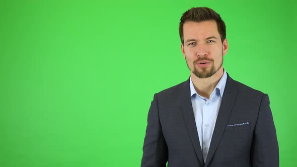 A Young Handsome Businessman Talks To the Camera with a Smile - Green Screen Studio alt