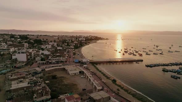 Drone Aerial Wide Shot of Ocean Sunset Strip Boats Pier Coastline Town Peru