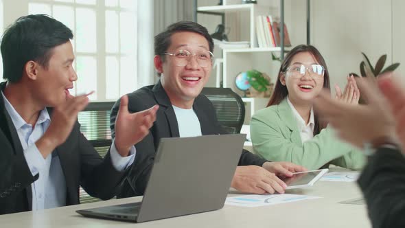 Young Asian Team Have Meeting In A Conference Room. They're Happy And Celebrate With Clapping Hands alt