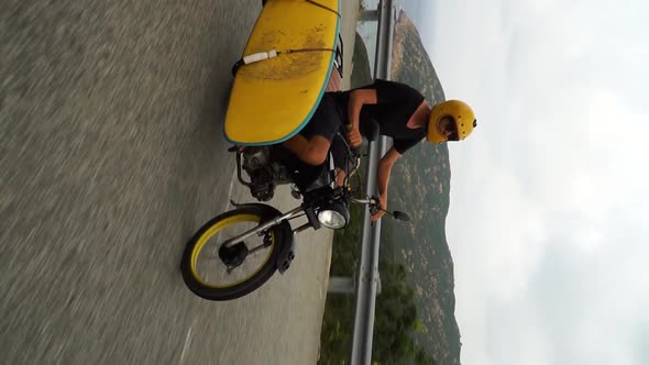 Young man rides motorcycle, shot sideways to use in portrait mode, use for IG stories alt