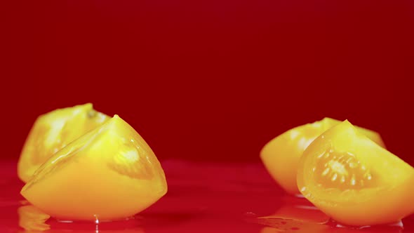 Set of Video Shots Ripe Yellow Tomato Slices Falling on Wet Reflective Table Surface alt