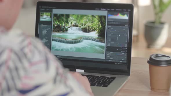 Man Works In Photo Editing App / Software On His Laptop Computer alt