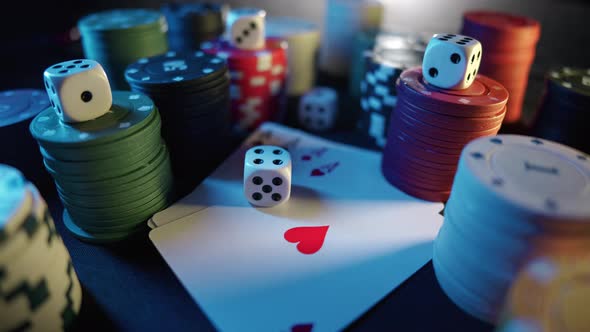 Casino Chips with Dice and Playing Cards on a Dark Table alt