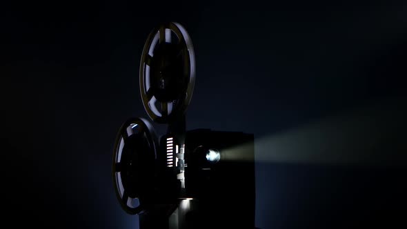 Film Projector Showing Movie in Dark Place. Light From Inside alt