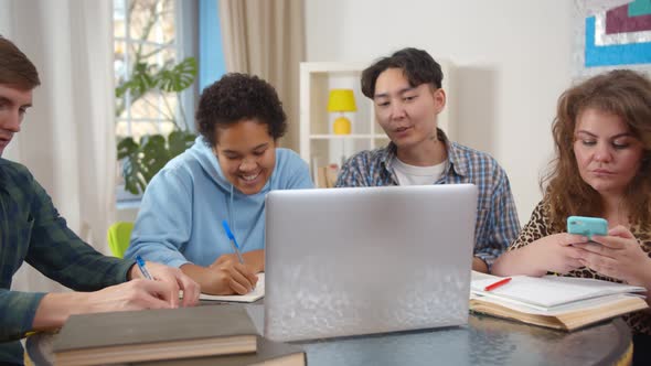 International Students Working at Project Together in Living Room alt